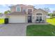 Charming two-story home boasts a manicured lawn and brick driveway with a two car garage at 7902 Silver Bass Ct, Kissimmee, FL 34747