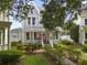 Beautiful two-story home with a charming front porch, lush landscaping, and mature trees at 819 Veranda Pl, Celebration, FL 34747