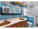Bathroom featuring dual sinks, a large mirror, and a subway-tiled shower with glass doors at 8508 Alveron Ave # 1, Orlando, FL 32817