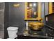 This one-of-a-kind bathroom features a gold colored bowl sink and black countertops and walls at 8929 Legacy Ct # 106, Kissimmee, FL 34747