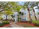 Inviting condo building with lush landscaping, mature trees, and accessible entry features at 8929 Legacy Ct # 106, Kissimmee, FL 34747
