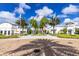 Inviting community entrance showcasing pristine landscaping, palm trees, and elegant white buildings under a blue sky at 925 Conch Rd, Davenport, FL 33896