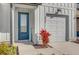 Close up of the house entrance, featuring a modern blue front door, landscaping, and attached garage at 925 Conch Rd, Davenport, FL 33896