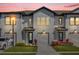 Beautiful two-story townhome with a front entry garage, blue door, and colorful landscaping at 925 Conch Rd, Davenport, FL 33896