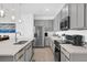 Modern kitchen features stainless steel appliances, light gray cabinets, and a spacious island with a sink at 925 Conch Rd, Davenport, FL 33896