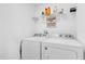 Convenient laundry room equipped with a washer, dryer, and overhead shelving for storage at 925 Conch Rd, Davenport, FL 33896