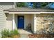 Inviting front porch with a stone accent wall, a blue front door, and room for seating, creating a cozy entry at 103 N Atlas Dr, Apopka, FL 32703