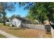 Side exterior view of the house showcasing a well-maintained yard, mature trees, and a fence at 103 N Atlas Dr, Apopka, FL 32703