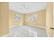 Bedroom featuring two windows with blinds, yellow walls, ceiling fan, and tile flooring at 109 Mcquigg Ave, Orlando, FL 32805