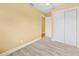 Bedroom with light wood-look floors, yellow walls, and a large closet with sliding doors at 109 Mcquigg Ave, Orlando, FL 32805