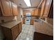 Galley kitchen features tile floors, wood cabinets, granite countertops, and white appliances at 110 Kasey Dr, Orlando, FL 32807