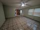 Open living room view showcasing the tile flooring, ceiling fan, and the kitchen in the background at 110 Kasey Dr, Orlando, FL 32807