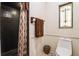 Bathroom featuring a shower, toilet, and stained glass window at 1101 N Valencia Ave, Howey In The Hills, FL 34737