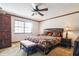 Bedroom features a ceiling fan, window, and bed with decorative pillows at 1101 N Valencia Ave, Howey In The Hills, FL 34737