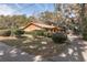 Well-kept front yard showcases this brick home with mature landscaping and a lengthy driveway at 1101 N Valencia Ave, Howey In The Hills, FL 34737