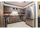 Functional kitchen featuring stainless steel appliances, rustic wood cabinets and tile floors at 1101 N Valencia Ave, Howey In The Hills, FL 34737