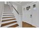 Bright foyer with hardwood floors, staircase, and white trim and paneled doors at 11507 Center Lake Dr, Windermere, FL 34786