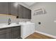 Functional laundry room with gray cabinets, white countertops, modern sink, and a new washer and dryer at 11507 Center Lake Dr, Windermere, FL 34786