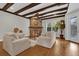 Cozy living room featuring hardwood floors, a stone fireplace, and beamed ceilings at 11507 Center Lake Dr, Windermere, FL 34786