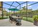 This covered patio features an umbrella, dining table and a view of putting green at 11507 Center Lake Dr, Windermere, FL 34786