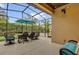 This screened patio features an umbrella, ceiling fan and an outdoor dining table at 11507 Center Lake Dr, Windermere, FL 34786