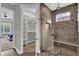 Modern shower with glass enclosure, pebble floor, and a window providing natural light at 11507 Center Lake Dr, Windermere, FL 34786