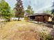 View of the spacious backyard featuring a patio with pergola, lawn area, mature trees and a metal fence at 14410 Sw 79Th Ter, Ocala, FL 34473