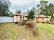 View of the backyard and side exterior of the house, with a partial view of a white fence at 14410 Sw 79Th Ter, Ocala, FL 34473