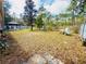 Expansive backyard with mature trees, lawn area, play set, patio with pergola and perimeter fencing at 14410 Sw 79Th Ter, Ocala, FL 34473