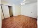 Bedroom with laminate floors, white walls, ceiling fan, and a closet in a well-lit room at 14410 Sw 79Th Ter, Ocala, FL 34473