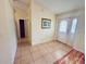 The foyer features neutral tile flooring with access to a coat closet and a glimpse into the rest of the home at 14410 Sw 79Th Ter, Ocala, FL 34473