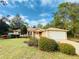 Well-kept single-story home featuring a front lawn with mature landscaping and an attached garage at 14410 Sw 79Th Ter, Ocala, FL 34473