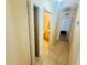 Hallway with tile flooring leading to the bathroom and a view of another room with an open closet at 14410 Sw 79Th Ter, Ocala, FL 34473