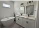 Bright bathroom featuring a standalone tub, dual vanity with black fixtures, and light gray wood-look floors at 171 Marion Oaks Trl, Ocala, FL 34473