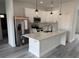 Stylish kitchen showcasing white cabinetry, a stainless steel refrigerator, and a functional island at 171 Marion Oaks Trl, Ocala, FL 34473