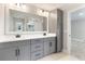 Beautiful bathroom with gray double vanity, quartz countertop, sleek black hardware, and a large mirror at 1809 Simonton Ave, Orlando, FL 32806