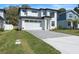 A modern two-story home features a pristine white facade, gray driveway, and manicured lawn at 1809 Simonton Ave, Orlando, FL 32806