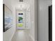 Bright hallway with modern light fixture and a view to the front yard through the glass door at 1809 Simonton Ave, Orlando, FL 32806