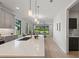 Modern kitchen featuring a large island with quartz countertop, stainless steel sink, and bright, airy lighting at 1809 Simonton Ave, Orlando, FL 32806