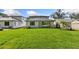 Large, newly seeded backyard with lush green grass, white exterior walls, and a covered patio area at 1811 Simonton Ave, Orlando, FL 32806