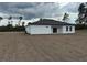 Single-story home features a freshly seeded yard, sliding glass doors, and white stucco at 2293 Sw 178Th Lane Rd, Ocala, FL 34473