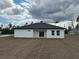 Home's backyard with sliding glass doors, windows, white stucco and newly laid seeded lawn at 2293 Sw 178Th Lane Rd, Ocala, FL 34473