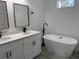 Modern bathroom with double sink vanity, matte black faucets and a freestanding soaking tub next to the vanity at 2293 Sw 178Th Lane Rd, Ocala, FL 34473