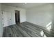 Spacious bedroom featuring new gray wood flooring, a neutral wall color, and a hallway leading to the bathroom at 2293 Sw 178Th Lane Rd, Ocala, FL 34473