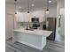 Well-lit kitchen featuring stainless steel appliances, white cabinets and island with quartz countertops and pendant lights at 2293 Sw 178Th Lane Rd, Ocala, FL 34473