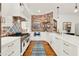 Modern kitchen featuring white cabinetry, stainless steel appliances, brick backsplash and farmhouse sink at 234 N Lakeview Ave, Winter Garden, FL 34787