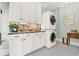 Modern laundry room with stacked washer and dryer and stylish mosaic backsplash at 234 N Lakeview Ave, Winter Garden, FL 34787