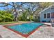 Beautiful pool with brick trim and water features is surrounded by landscaping and mature trees at 234 N Lakeview Ave, Winter Garden, FL 34787