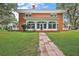 Red brick two story home with white trim, a stone walkway, and lush green lawn at 2525 Cr 543, Sumterville, FL 33585