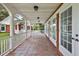 Spacious outdoor porch area featuring brick accents, white columns and a red-tiled floor at 2525 Cr 543, Sumterville, FL 33585